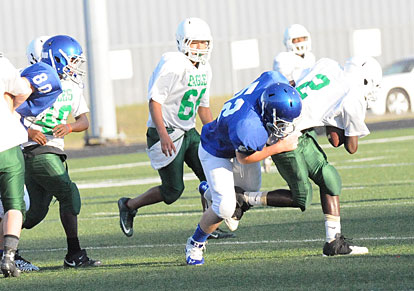 Taylor Martin (52) latches onto Forest Heights quarterback Deunte Moody as Brantley Thomas (80) pursues. (Photo by Kevin Nagle)