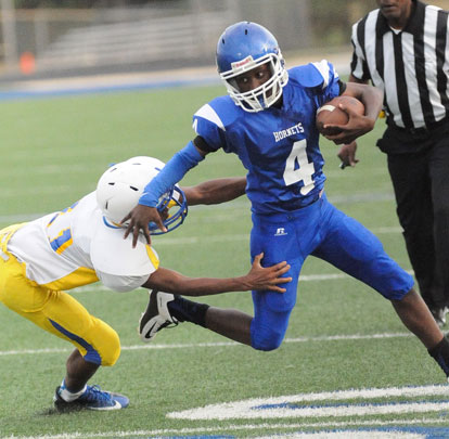 Christian Cain (4) tries to avoid a Lakewood tackler. (Photo by Kevin Nagle)