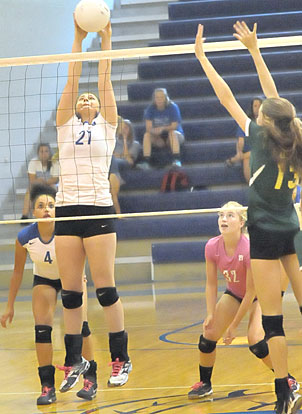 Alex Dillard (21) gets to a ball on a dink as teammates Kaci Squires (18) and Whitney Brown (32) get set for a return. (Photo by Kevin Nagle)