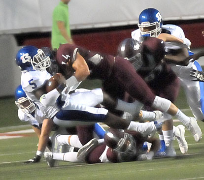 DeAmonte Terry (5) is stopped by Benton's Ben Brassuell (14). (Photo by Kevin Nagle)