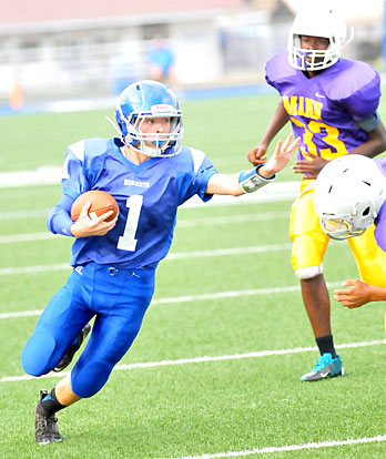 Bryant Blue quarterback Jake Meaders turns upfield as Horace Mann's Favian Delph (33) pursues. (Photo by Kevin Nagle)
