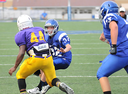 Dalen McDonald (32) moves to cut past Horace Mann's Kendel Givens as tackle David Shifflet arrives to help out. (Photo by Kevin Nagle)