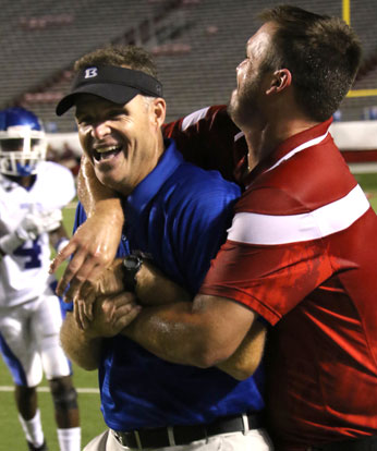 Bryant head coach Paul Calley, left, gets a big hug from offensive coordinator and former Hornets player Lance Parker following the team's Salt Bowl win over Benton. (Photo by Rick Nation)