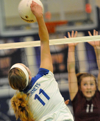 Reagan Blend reaches above the net on a spike. (Photo by Kevin Nagle)