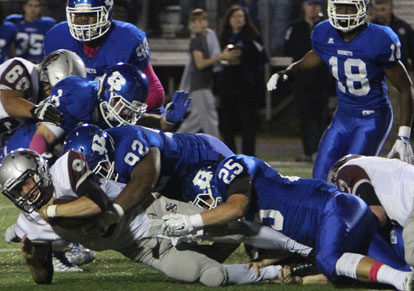 Hayden Knowles, Mario Waits and Devon Alpe bring down Siloam Springs quarterback Jordan Norberg. (Photo by Rick Nation)