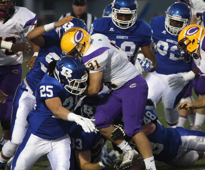 Devon Alpe and his defensive cohorts stack up Catholic running back Austin Berry (31). (Photo by Rick Nation) 