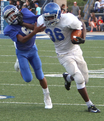 Bryant White running back Myles Aldridge stiff arms a Bryant Blue defender. (Photo by Rick Nation)