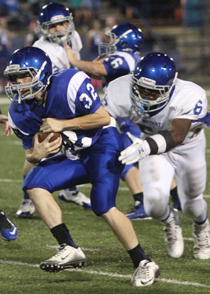 Bryant White's Austin Bailey (56) tries to bring down Bryant Blue runner Dalen McDonald (32). (Photo by Rick Nation)