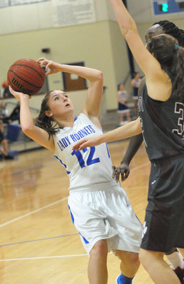 Megan Lee (12) looks to get a shot up over a pair of Benton defenders. (Photo by Kevin Nagle)
