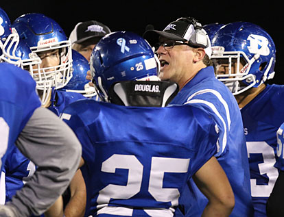 Defensive coordinator Steve Griffith gathers the Bryant defense around him during a timeout. (Photo by Rick Nation)