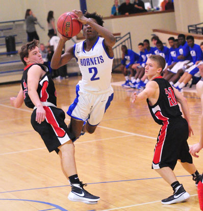 Rodney Lambert (2) leans in between a pair of Cabot White defenders to launch a shot. (Photo by Kevin Nagle)