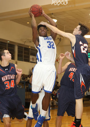 Lowell Washington (32) absorbs a foul from Rogers Heritage defender Will Moss. (Photo by Rick Nation)