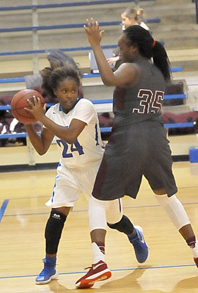 Kalia Walker (24) looks for room around Benton's Tamia Halk. (Photo by Kevin Nagle)