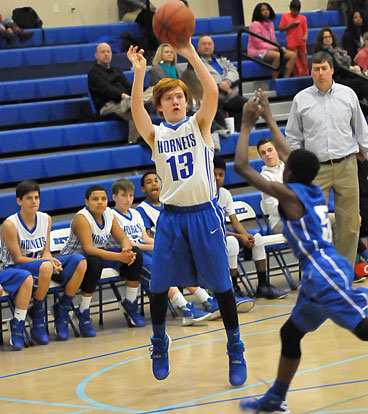 Bryant Blue's Ben Devine (13) takes a shot over Bryant White"s Kaylon Thurston. (Photo by Kevin Nagle)