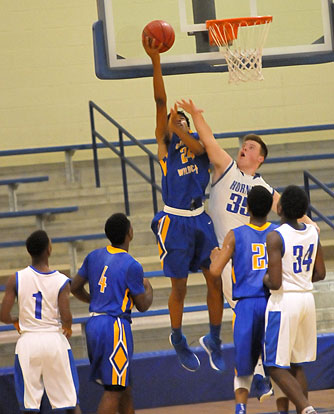 Blaise Smith (35) tries to block a shot as teammates Randy Thomas (34) and Daelin Drake (1) looks on. (Photo by Kevin Nagle)