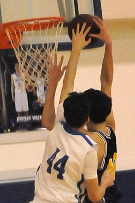 Kyle Sahr (44) comes from behind to block a shot by Catholic's 6-10 Brian Beckwith. (Photo by Kevin Nagle)