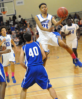 Josh Robinson goes up for a scoop shot over a Conway White defender as teammates Alex Blair (33) and Kajuan Robinson (44) trail the play. (Photo by Kevin Nagle)