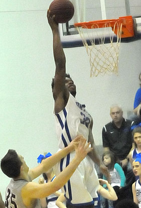 Lowell Washington (32) scores over Siloam Springs' Kyle Snarly. (Photo by Kevin Nagle)