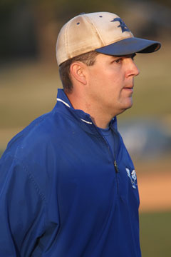 Bryant third-base coach Travis Queck glances toward the dugout for a sign from head coach Kirk Bock. (Photo by Rick Nation)