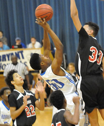 Ahmad Adams (50) tries to get a shot up around Russellville's Braylon McKinley. (Photo by Kevin Nagle)