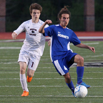 Bryant's Connor Qualls (4) dribbles ahead of Benton's Tyler Sandiver (1). (Photo by Rick Nation)