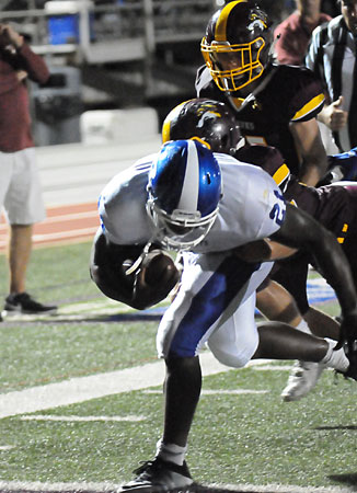 Cameron Coleman staggers as he surges past Lake Hamilton defenders. (Photo by Kevin Nagle)