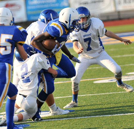 Trey Williams (2) and a teammate puts the clamps on as Aiden Adams (7) arrives to help out. (Photo by Kevin Nagle)