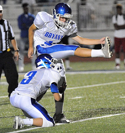 Grayson Scoles boots an extra point out of the hold of Jaeger Burks to set the final score in overtime. (Photo by Kevin Nagle)