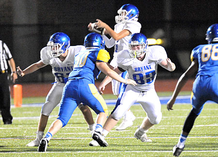 Quarterback Jake Meaders controls a high snap in the background as Brantley Thomas (67) and Tanner Wilson (83) provide protection. (Photo by Kevin Nagle)