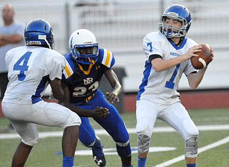 Aiden Adams (7) looks for an open receiver as North Little Rock's Fredrick O'Donald pressures and Bryant's Connor Coleman (4) tries to buy him some time. (Photo by Kevin Nagle)