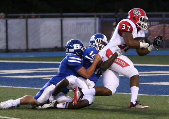 Jakob Neel and Antonio Rice drag down Northside's Colby Fleming at the 1. (Photo by Rick Nation)