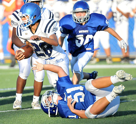 Conway Blue running back Isaiah Duncan (28) tries to get by Bryant White's Christian Del Castillo (51) and Chance Clendening (50). (Photo by Kevin Nagle)