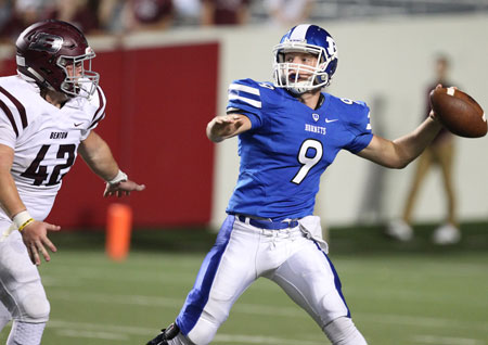 Quarterback Beaux Bonvillain winds up for a pass as Benton's Brayden Harris applies pressure. (Photo by Rick Nation)