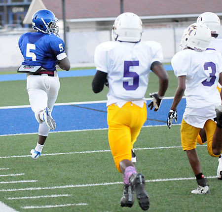 Myles Aldrige (5) looks over his shoulder at the Horace Mann defenders chasing him as he's about to head into the end zone at the end of a 72-yard run. (Photo by Kevin Nagle)