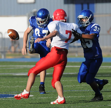 Baker Gray (87) follows through on a punt as Sabino Olivera (35) protects with a block on Cabot Red's Ian Taylor. (Photo by Kevin Nagle)