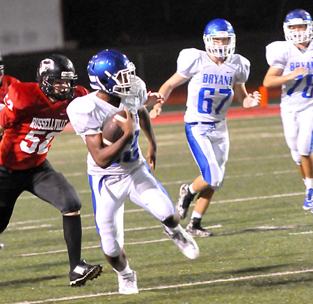 Ahmad Adams sprints upfield off blocks by Brantley Thomas (67) and Brayden Lester (78). (Photo by Kevin Nagle)