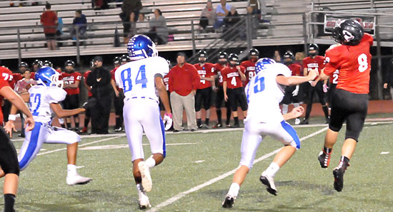 Peyton Dillon (75), Catrell Wallace (84) and Dayton Land (52) chase after Russellville quarterback Brayden Whitford. (Photo by Kevin Nagle)