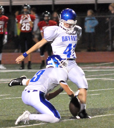 Grayson Scores kicks an extra point out of Jaeger Burks' hold. (Photo by Kevin Nagle)