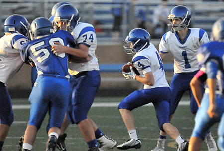 River Gregory (4) takes a handoff from Garrett Wilson (1) as Peter Elswick (74) provides interference. (Photo by Kevin Nagle)