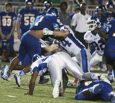 Nathan Mayes (44) smacks North Little Rock fullback Darius Austin (1) as Avery Everett (43) scrambles to get in on the tackle along with Antonio Todd (32). (Photo by Rick Nation)