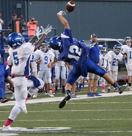 Hayden Schrader (12) reaches high to knock down a pass intended for Myles Aldrige (5). (Photo by Rick Nation)