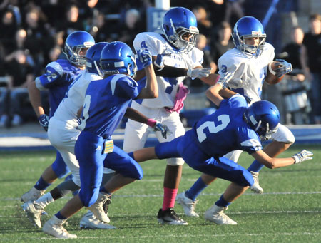 Austin Schroeder (2) tries to bring down Blaine Sears as Connor Coleman (4) tries to clear some room. (Photo by Kevin Nagle)