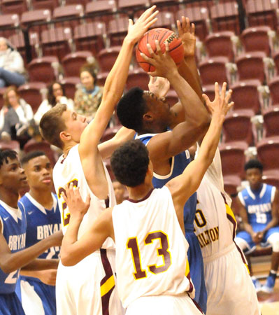 Ahmad Adams fights through a trio of Lake Hamilton defenders to get a shot away. (Photo by Kevin Nagle)