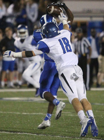 Brandon Murray (14) finds a way to haul in a pass despite the efforts of Conway's Jackson Freeman (18). (Photo by Rick Nation)