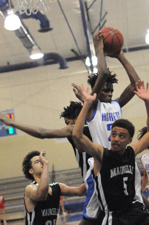 Colby Washington comes down with a rebound between two Maumelle players including Nathan Mills (5). (Photo by Kevin Nagle)